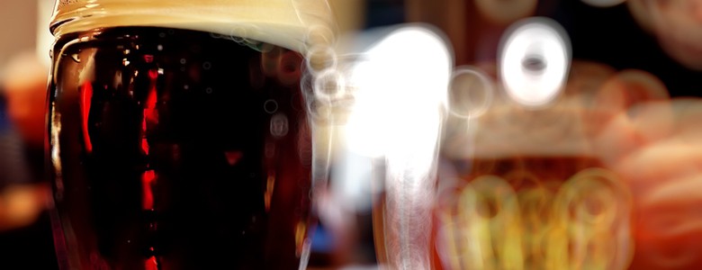 A full beer mug against a warm blurry background