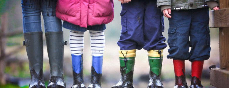 A line of children and an adult in muddy boots