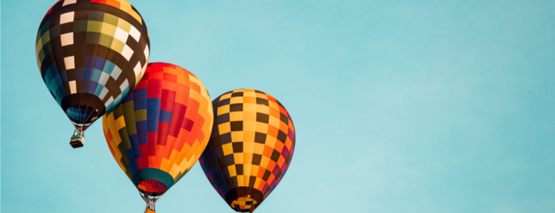Three hot air balloons in a clear blue sky