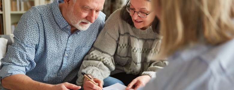 An older couple signing a form