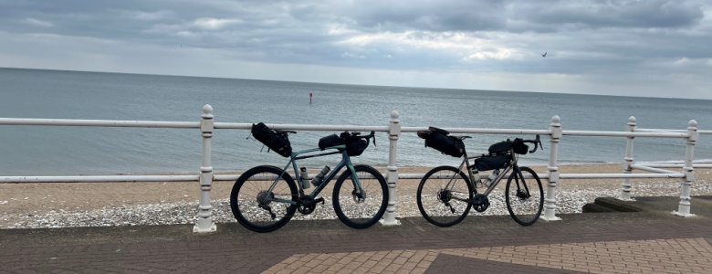 Two bikes leaning on railings beside a beach