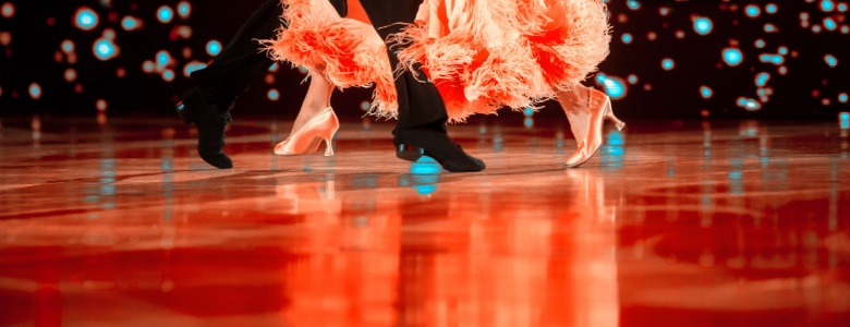 The feet of two ballroom dancers on a dance floor